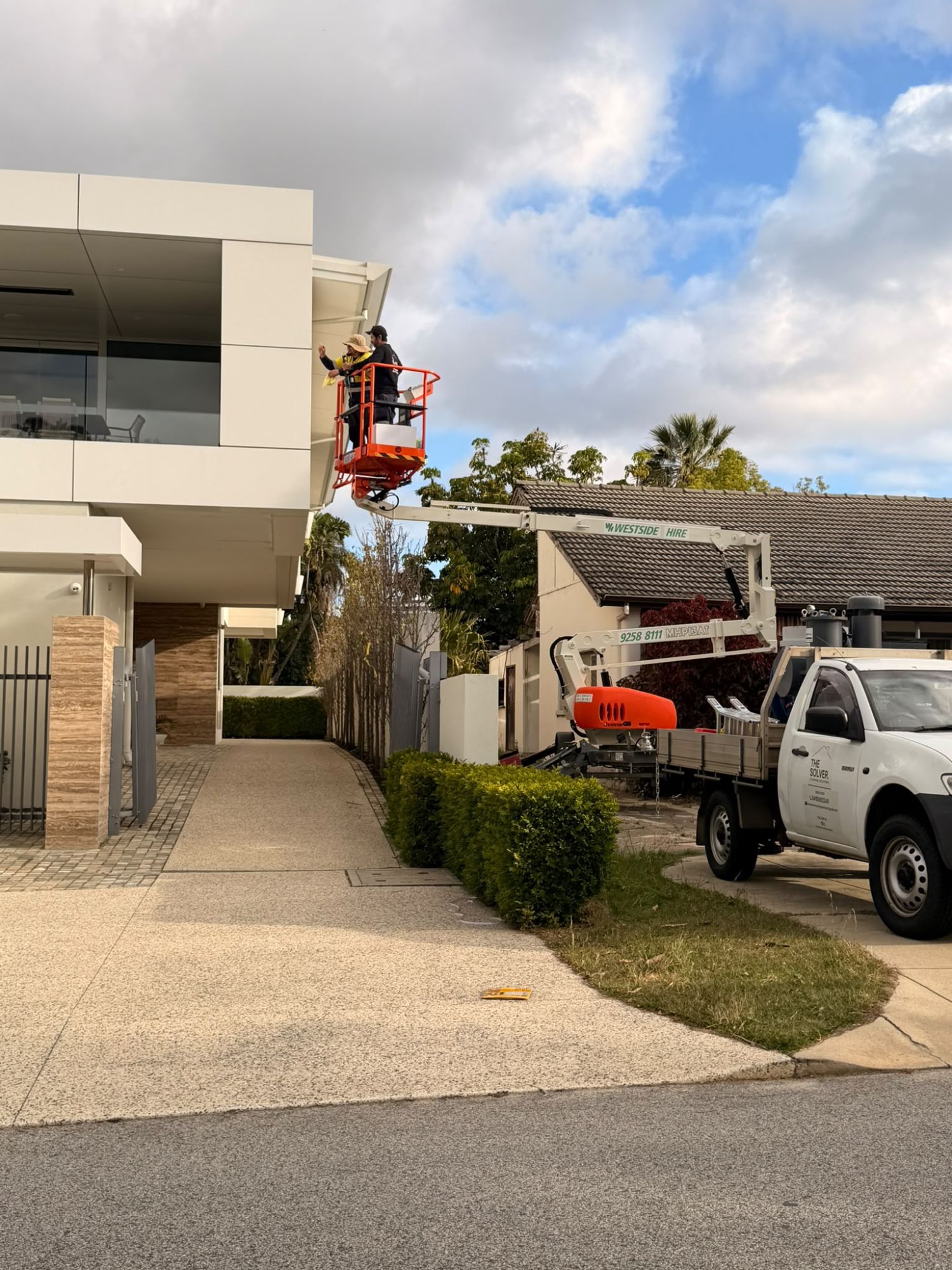The Solver team working at heights from a boom lift on a double-storey home in Perth